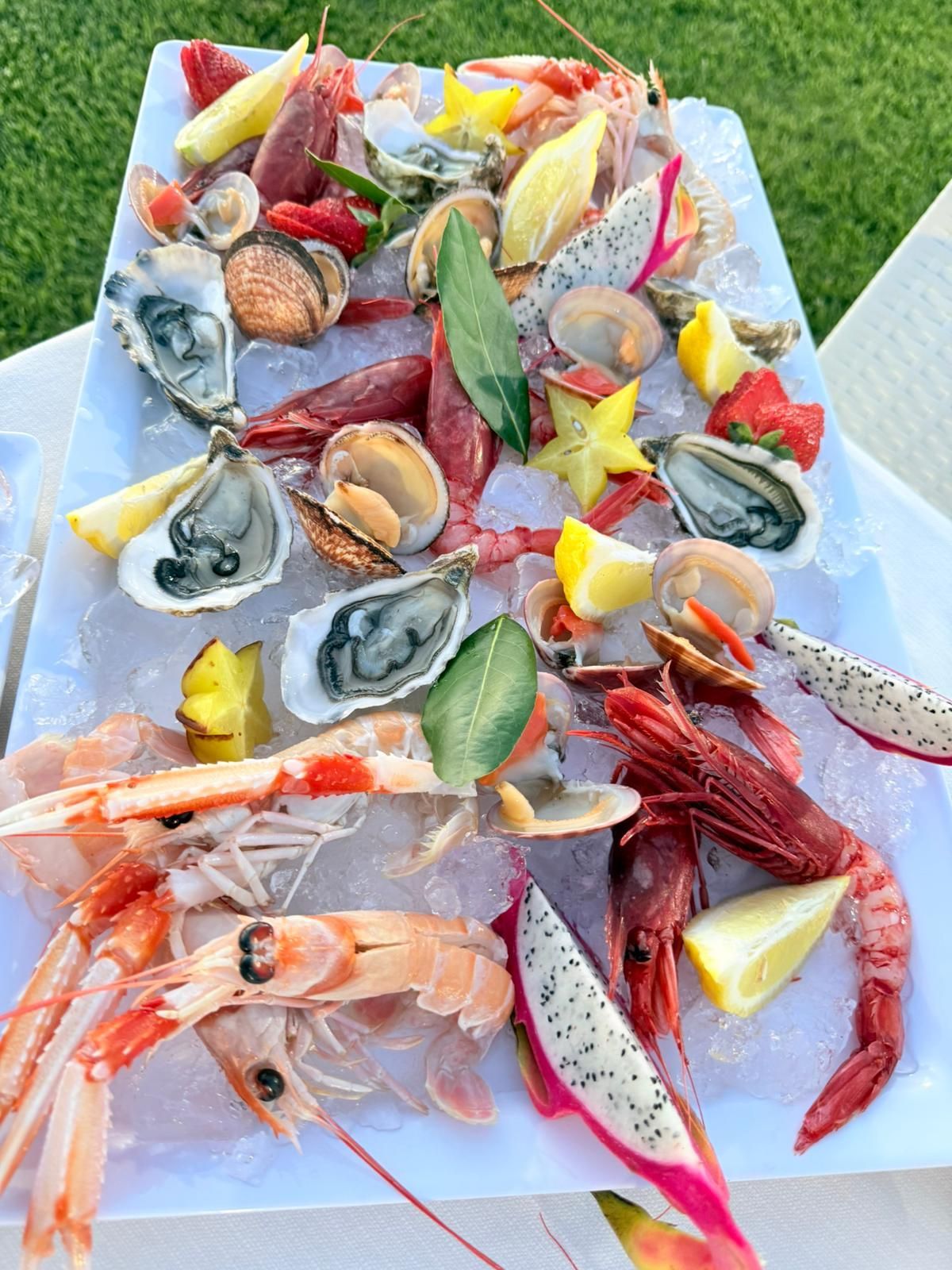 Assortimento di formaggi e salumi disposto in un'elegante presentazione a buffet con elementi vegetali.