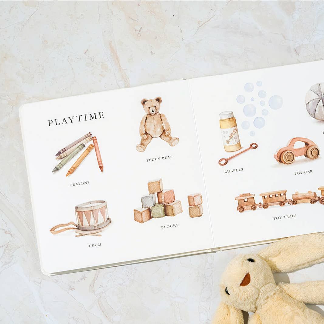 Open book with toy illustrations: crayons, teddy bear, bubbles, toy car, blocks, train, and drum.