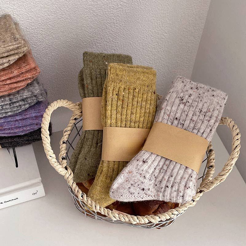 Basket of colorful knit socks. Various colors: green, gold, gray, brown, and more.