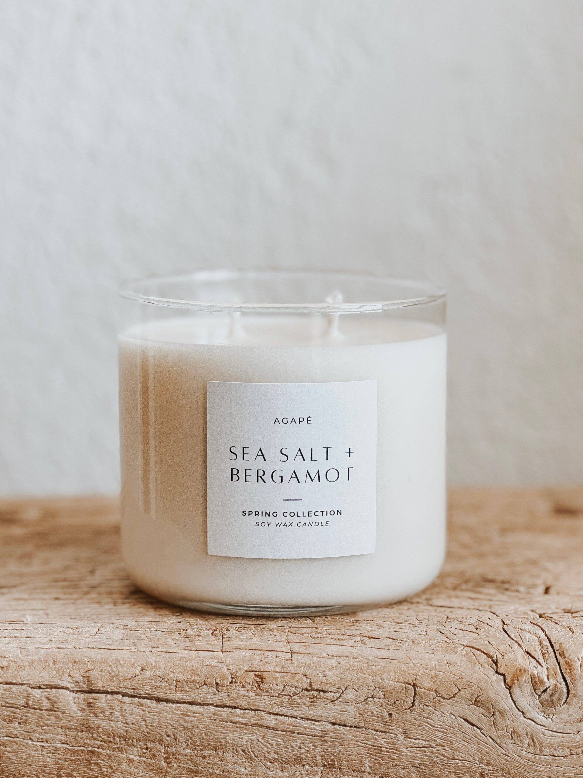 White candle in a glass jar, labeled 