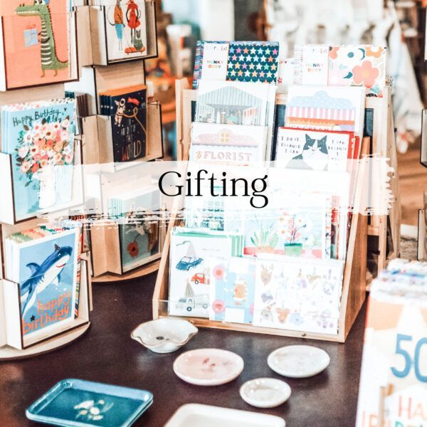 Gift shop display with greeting cards and small plates. 