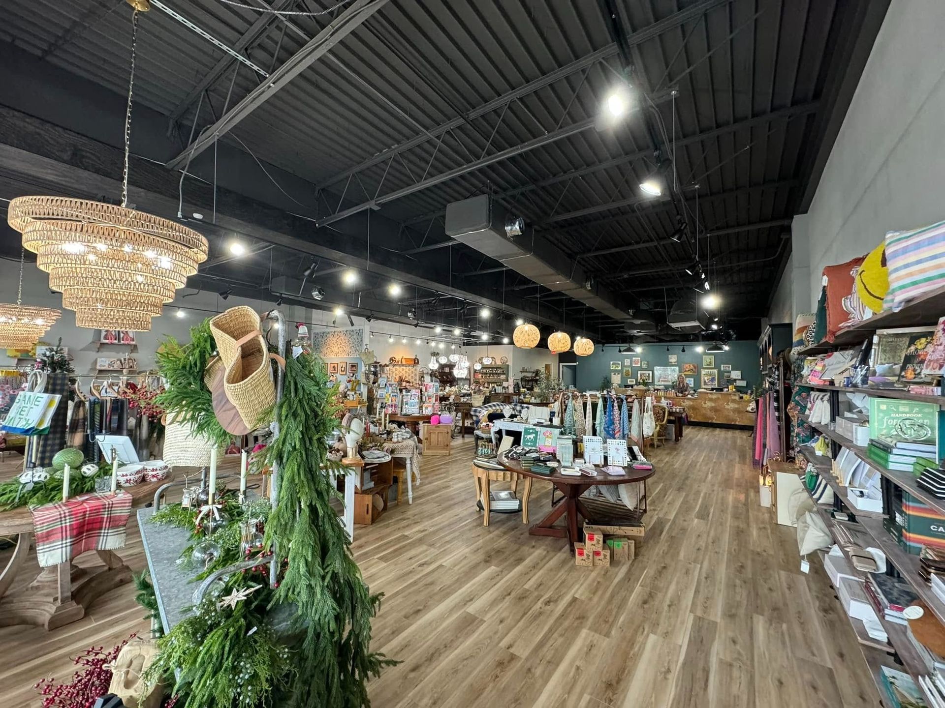 Interior of a store with wooden floors, displays of merchandise, and decorative lighting.