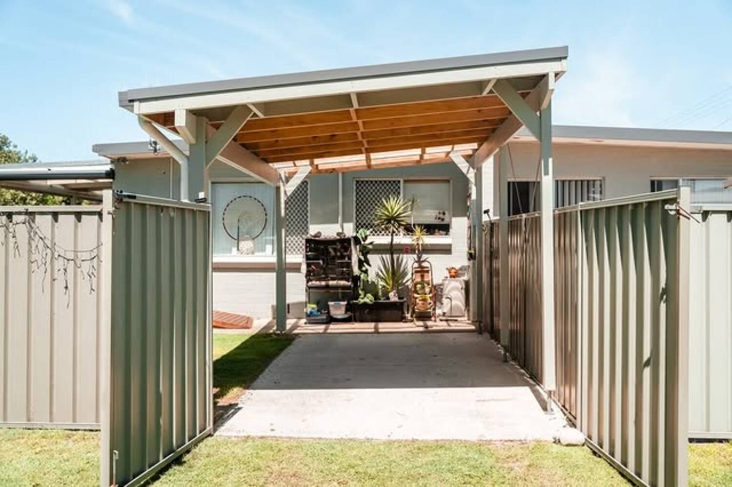 A Driveway Leading To A House With A Pergola And A Fence — Sedah Home Improvements In Port Macquarie, NSW