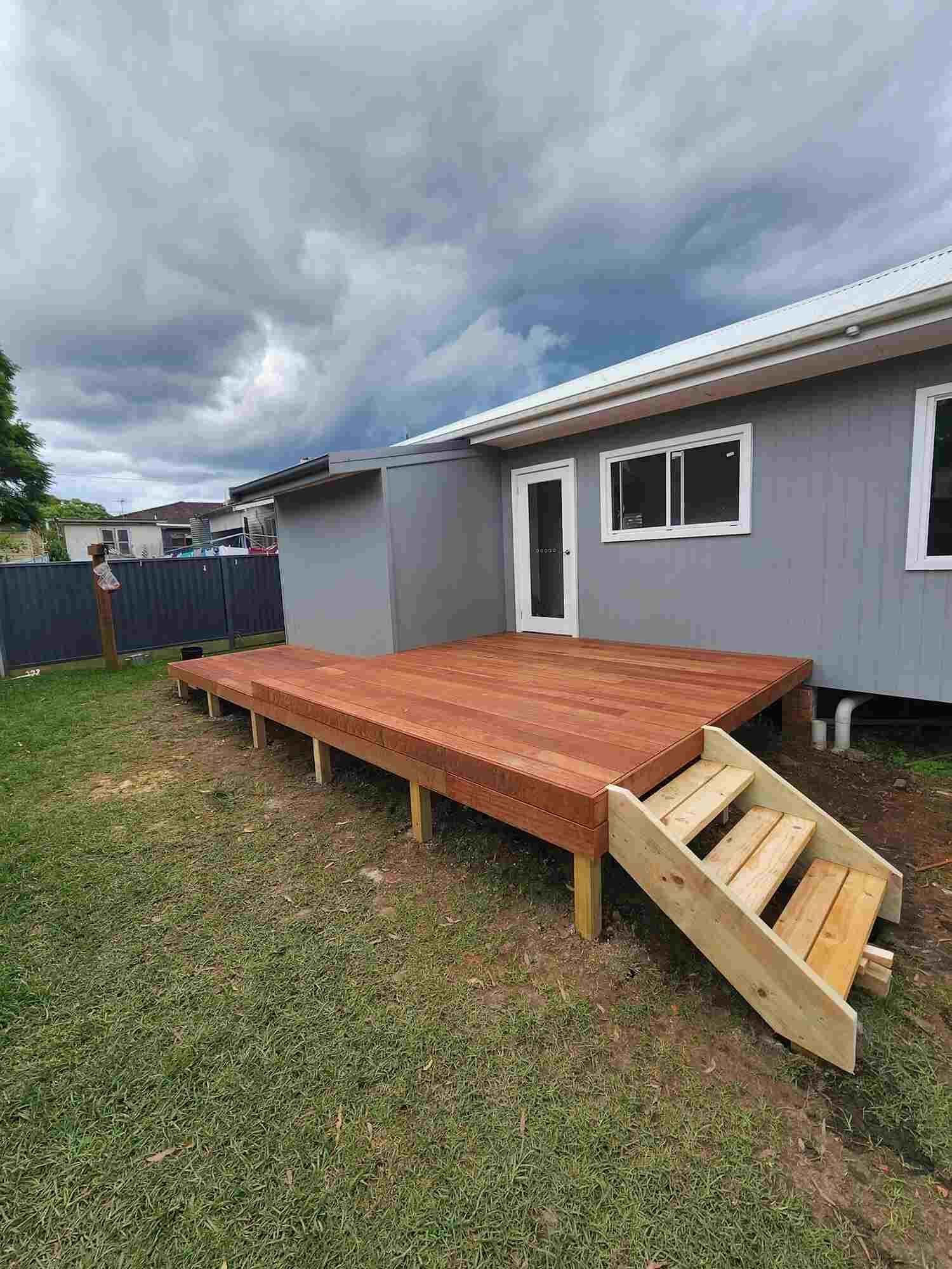 A House With A Wooden Deck And Stairs In Front Of It โ Sedah Home Improvements In Port Macquarie, NSW