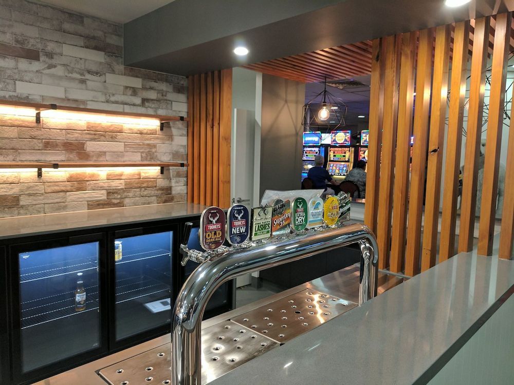 A Bar With a Row of Beer Taps and a Refrigerator — Stone Effects In Forest Glen, QLD