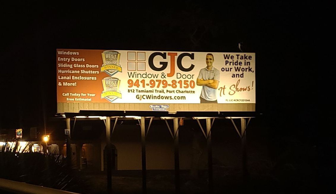 A billboard for a company called gjc is lit up at night