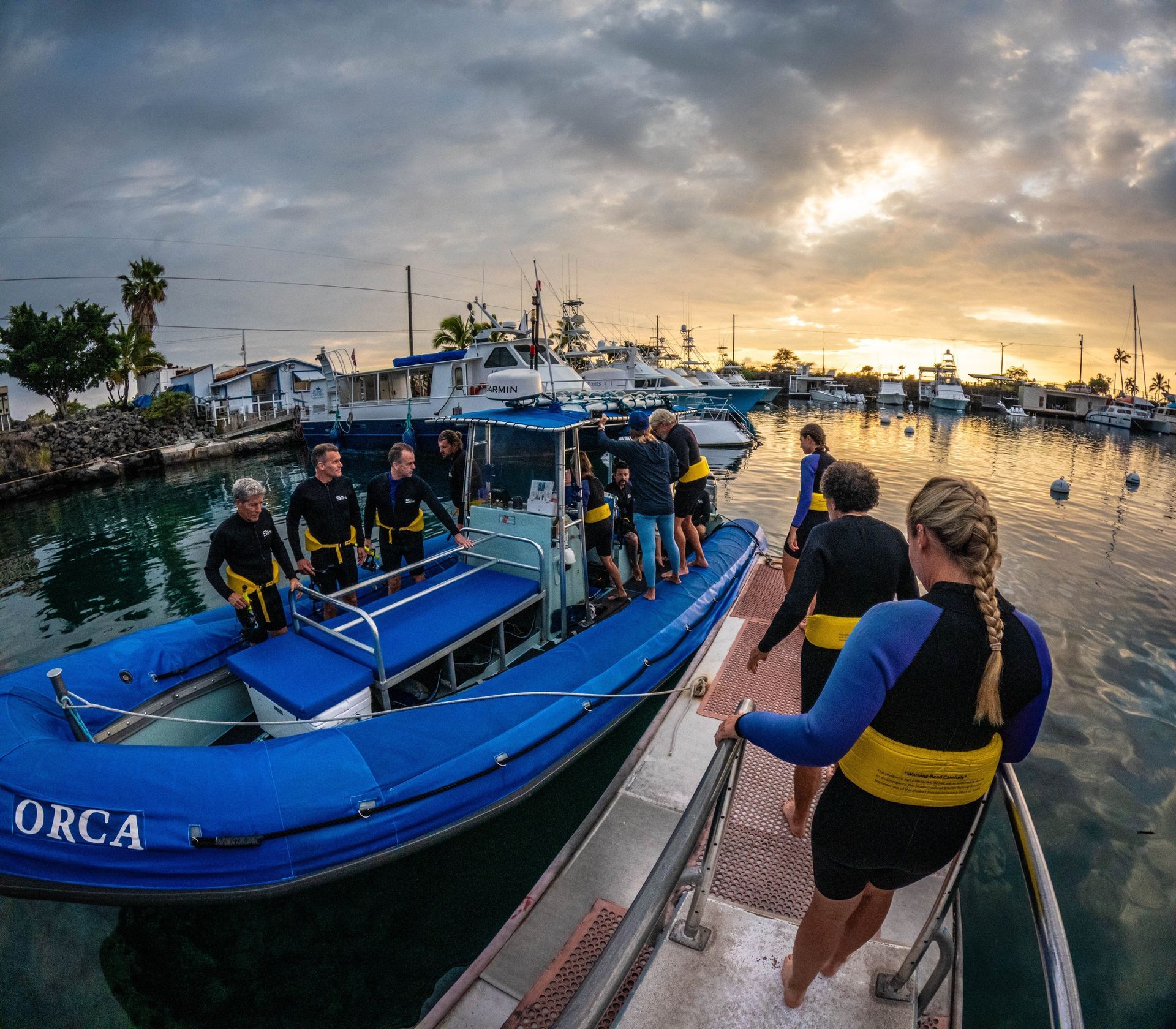 People boarding a blue boat labeled