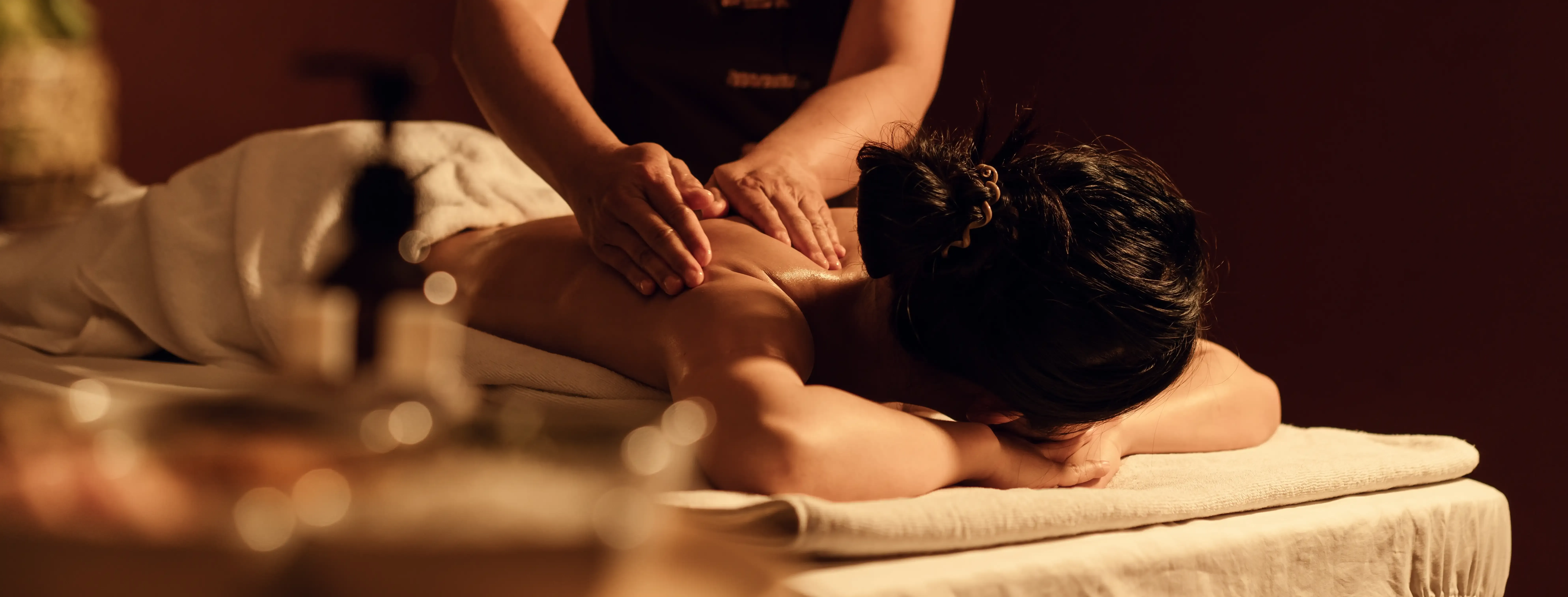 Person receiving a back massage in a spa setting. Hands are massaging the person's back. — First Avenue Remedial Massage in Maroochydore, QLD