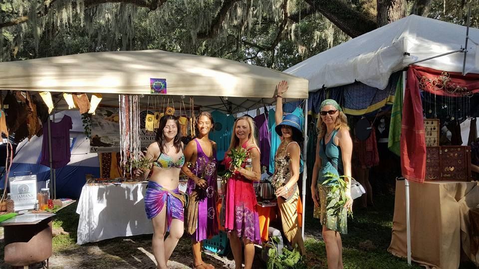 A group of women are standing in front of a tent.