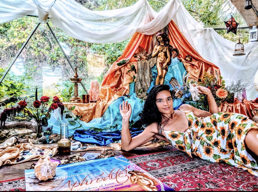 A woman in a sunflower dress is laying on the floor in a tent.