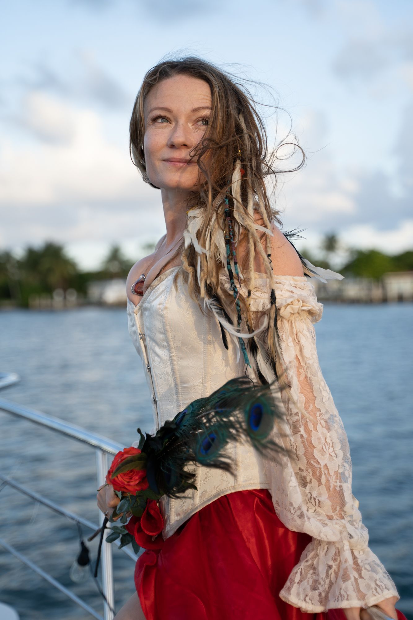 A woman in a pirate costume is standing on a boat.