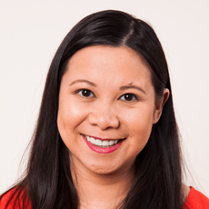 a woman with long black hair is smiling and wearing a red shirt