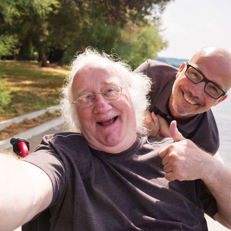 two men are posing for a picture and one is giving a thumbs up