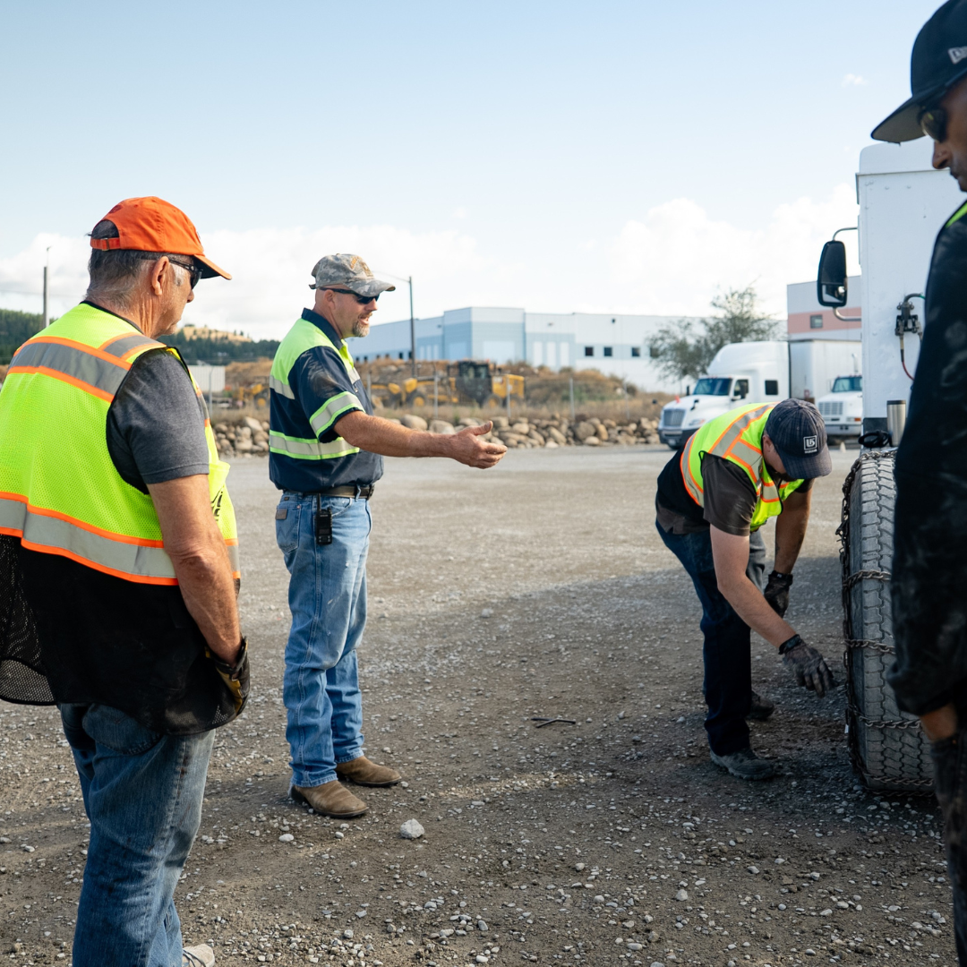 A CDL instructor is teaching cdl students in a training yard