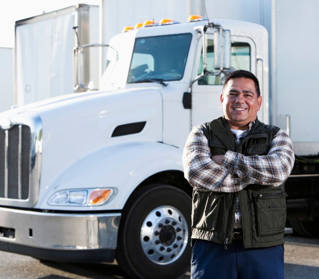 A man standing in front of a white truck with his arms crossed for CDL training
