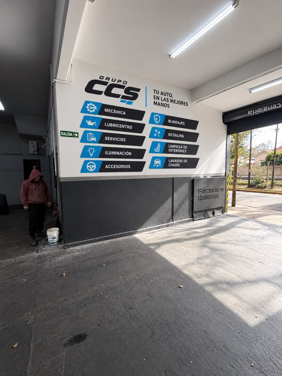 Entrada interior con un gran letrero de CCS y paneles direccionales junto a una puerta abierta
