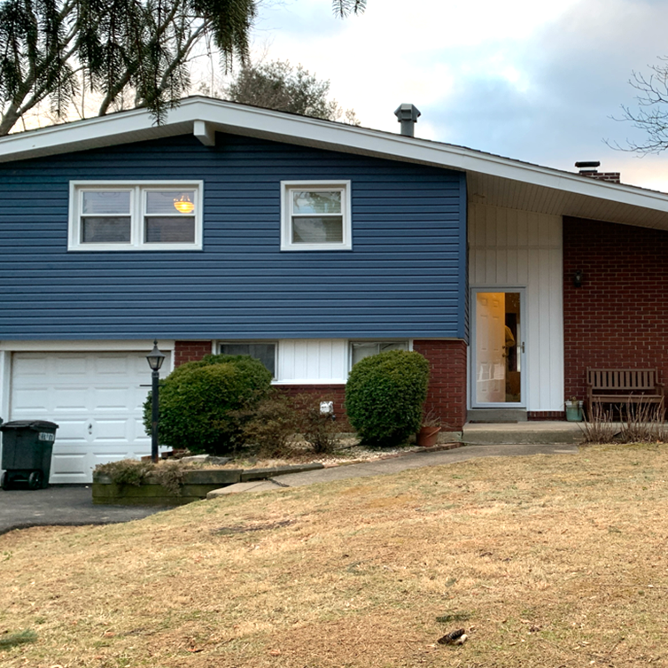 A house with a blue siding and a white garage door