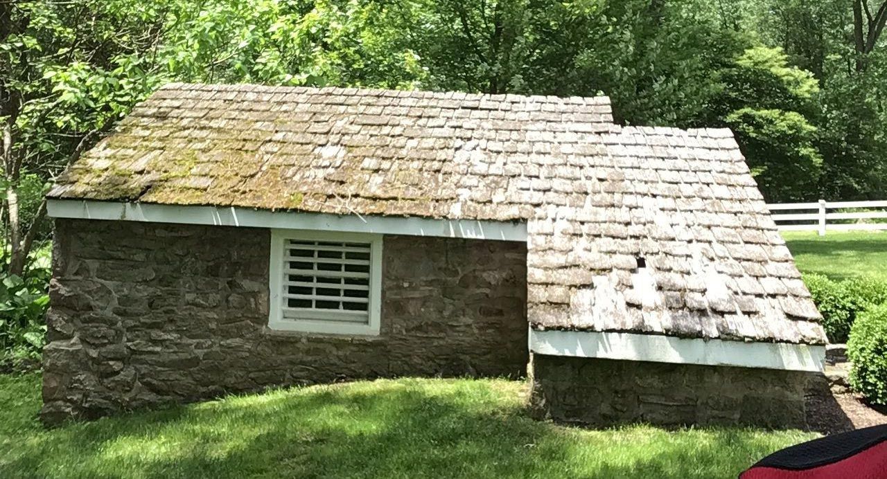 a small house with a roof that is covered in moss .