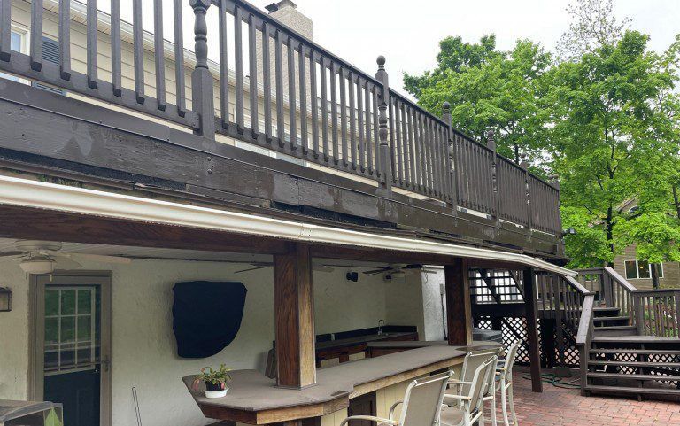 a large deck with a bar and chairs on it .