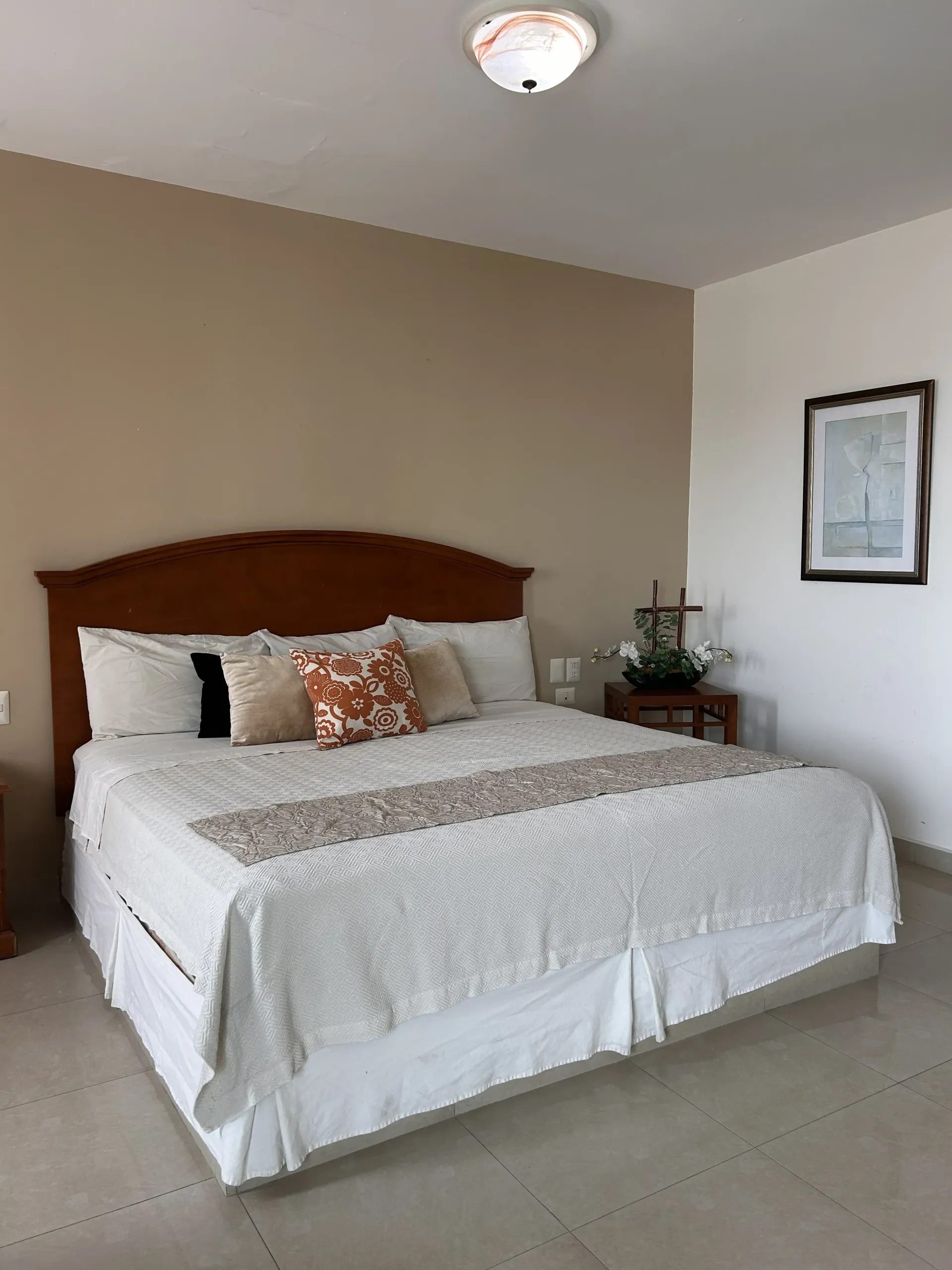 Una habitación de hotel con una cama grande, paredes en tonos neutros
