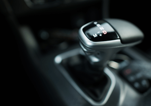 Close-up of a car gear shift knob in a dark interior