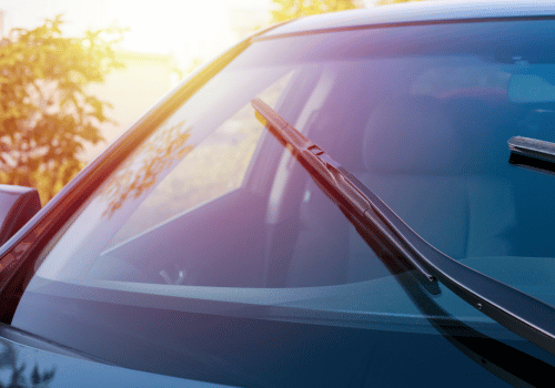 Windshield wipers on a car in warm sunlight