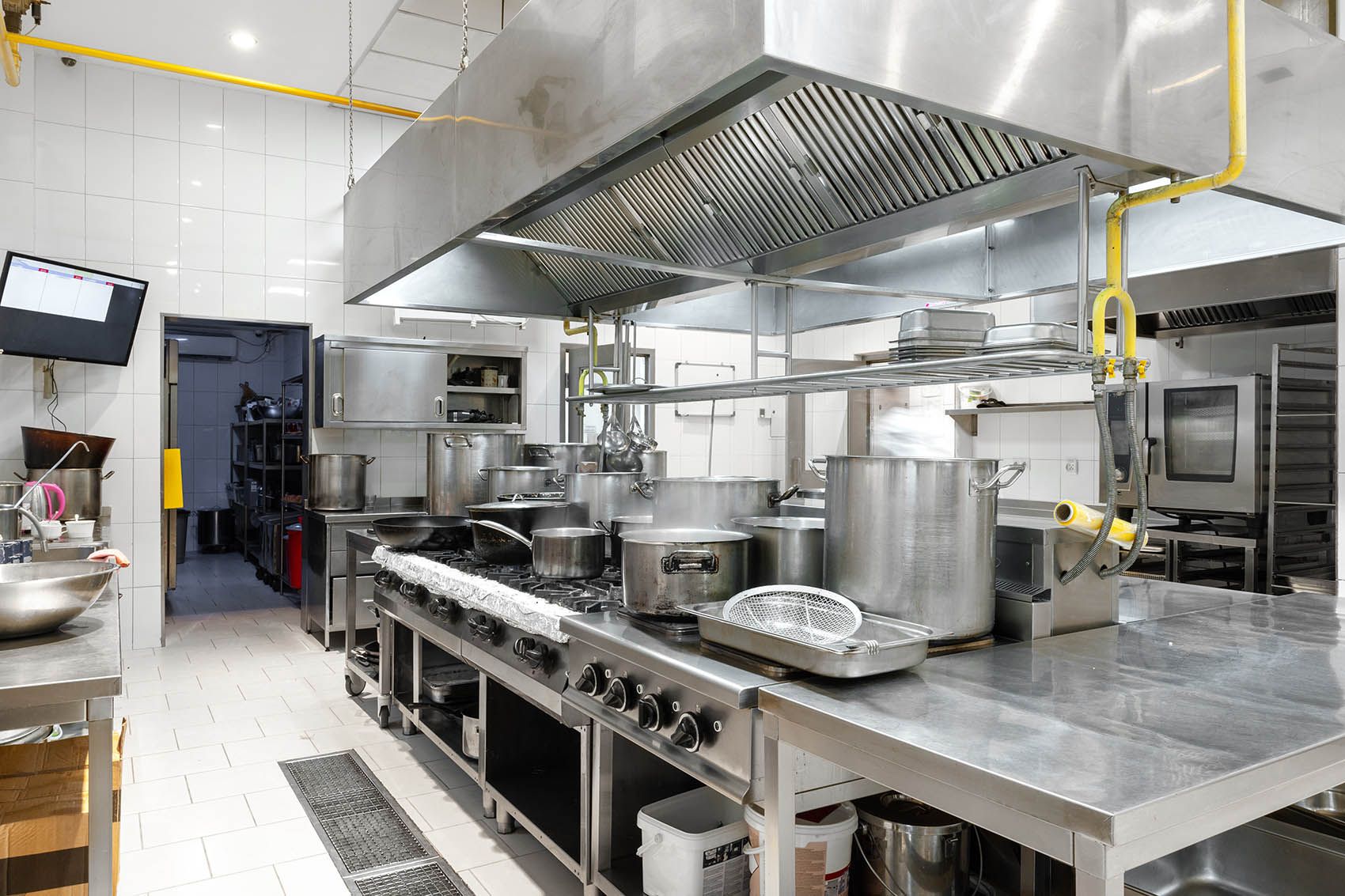 A kitchen with stainless steel appliances and a refrigerator.