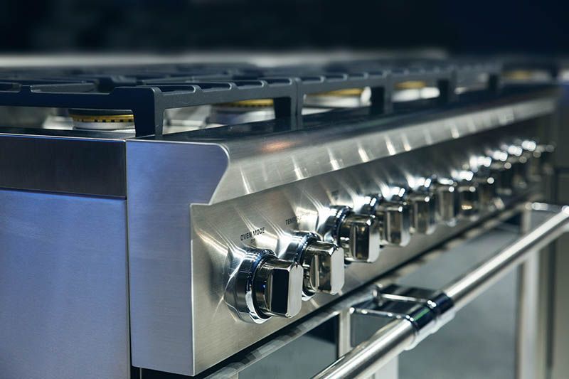 A stainless steel stove with a lot of knobs on it