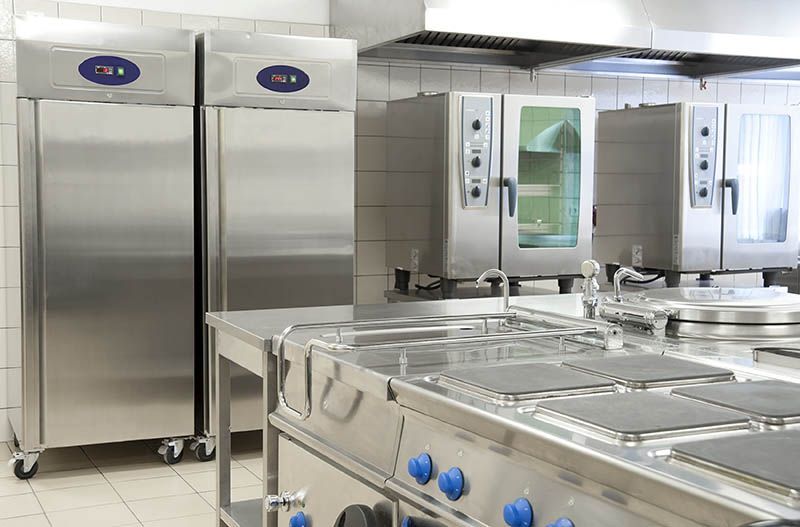A kitchen with stainless steel appliances and a refrigerator.