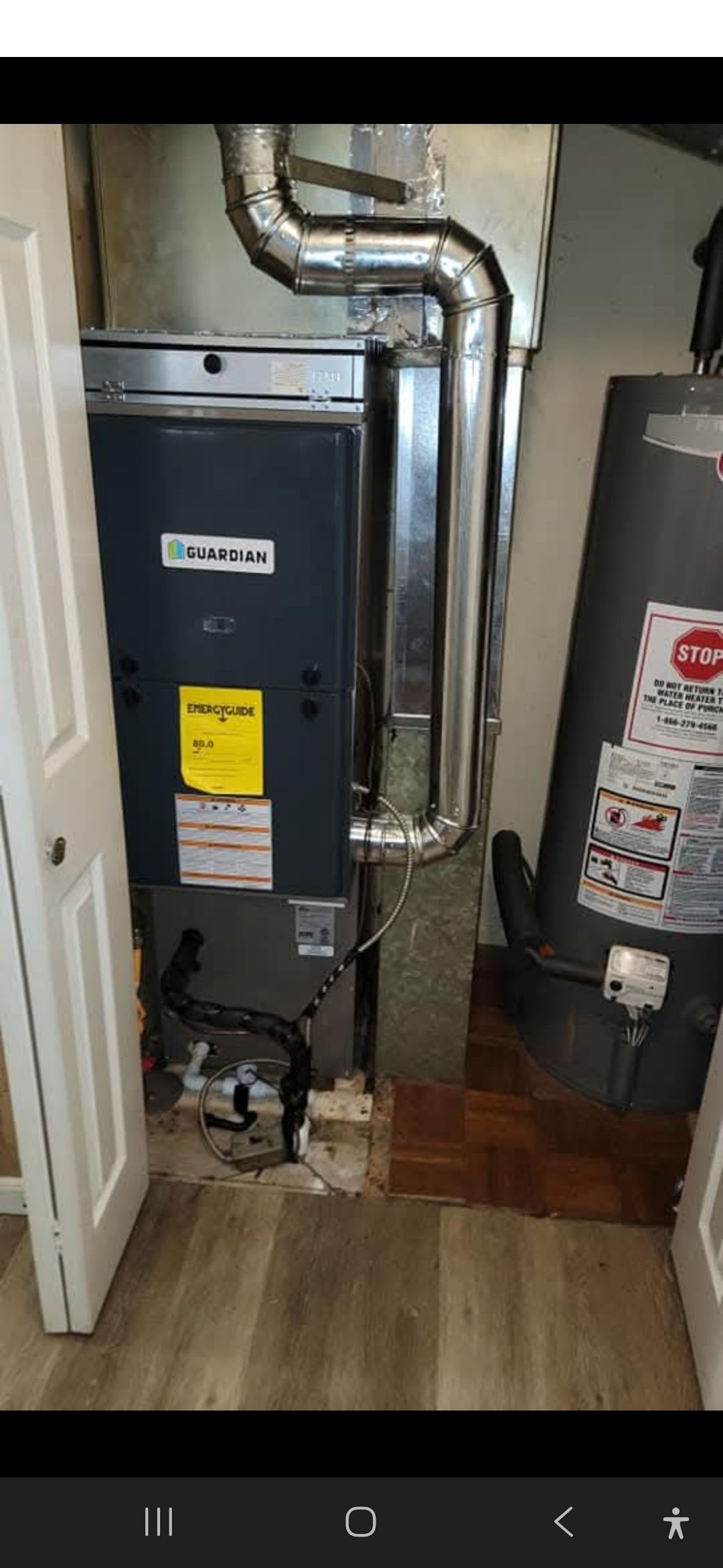 A furnace and water heater are in a utility closet with ductwork.