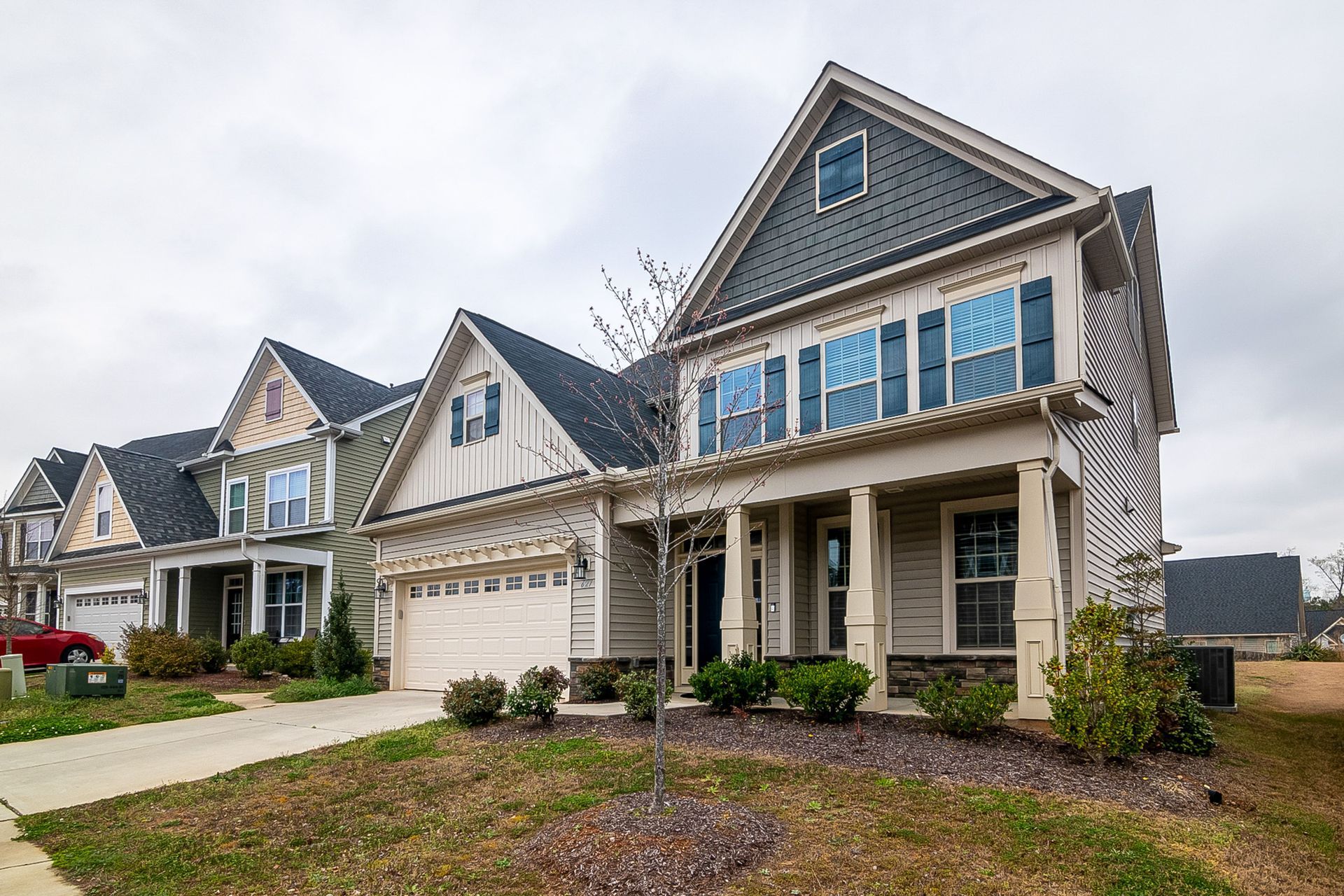 Row of suburban houses with gabled roofs and a driveway in front