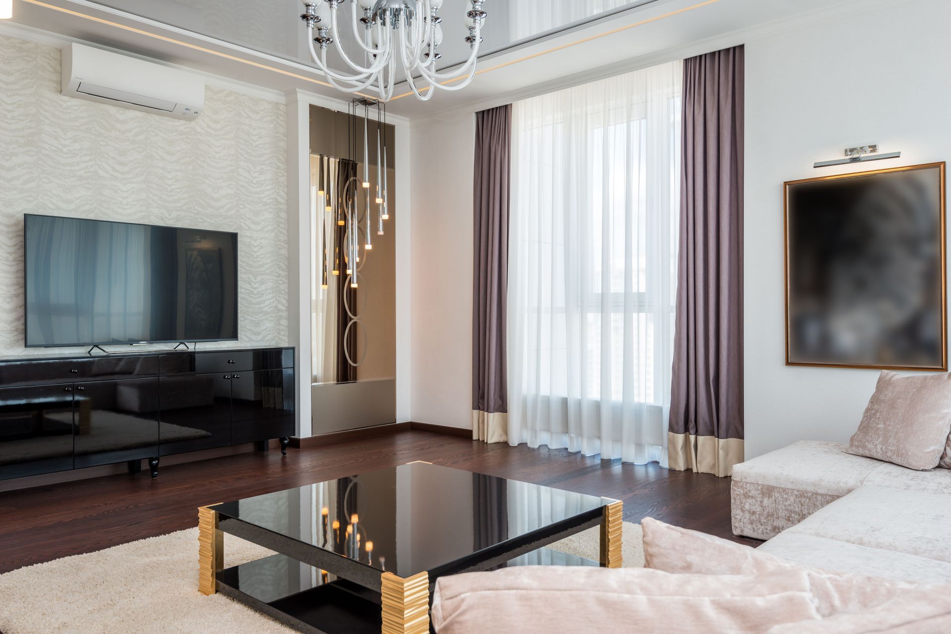 Modern living room with TV, white sofas, glass coffee table, and floor-to-ceiling windows