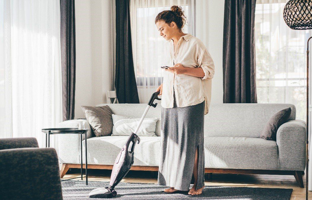 Woman cleaning the floor using vacuum