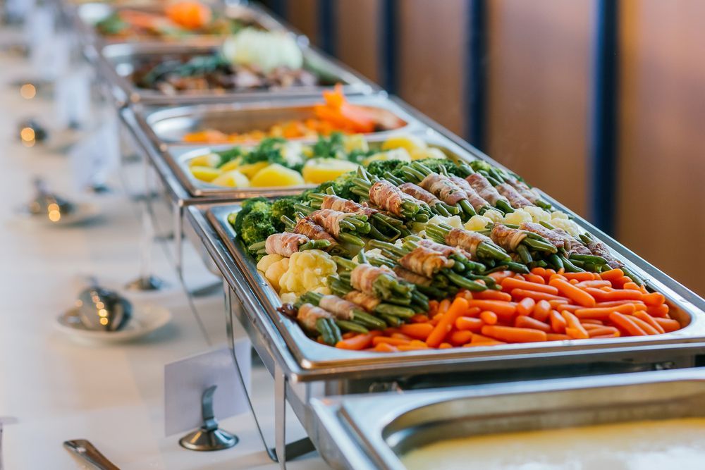 A long buffet line filled with lots of different types of food.
