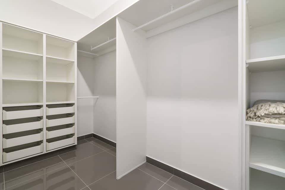An Empty Walk in Closet With White Shelves and Drawers — Top End Joinery In Yarrawonga, NT