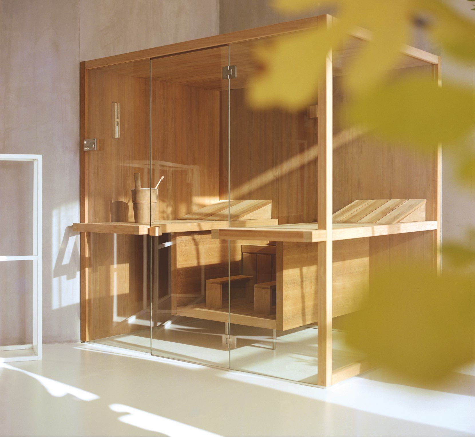 Una sauna in legno con porte in vetro e un annaffiatoio