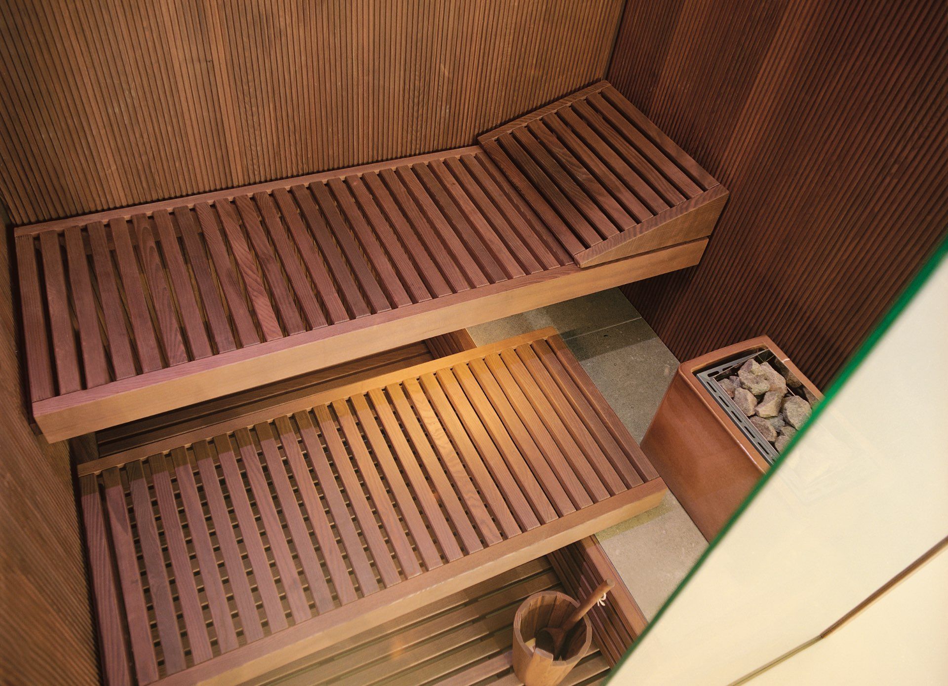 Una sauna in legno con un secchio e uno specchio