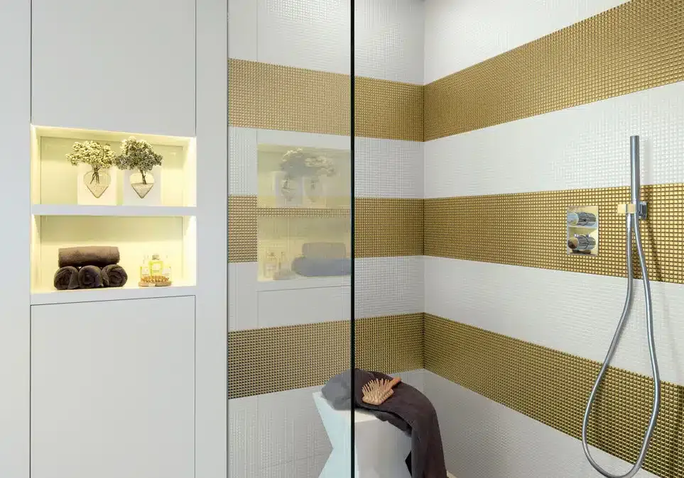 Un bagno con strisce dorate e bianche sulle pareti e una cabina doccia.