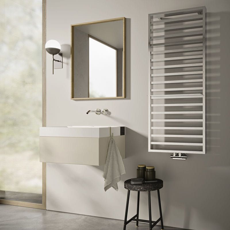 Un bagno con lavandino, specchio e portasciugamani