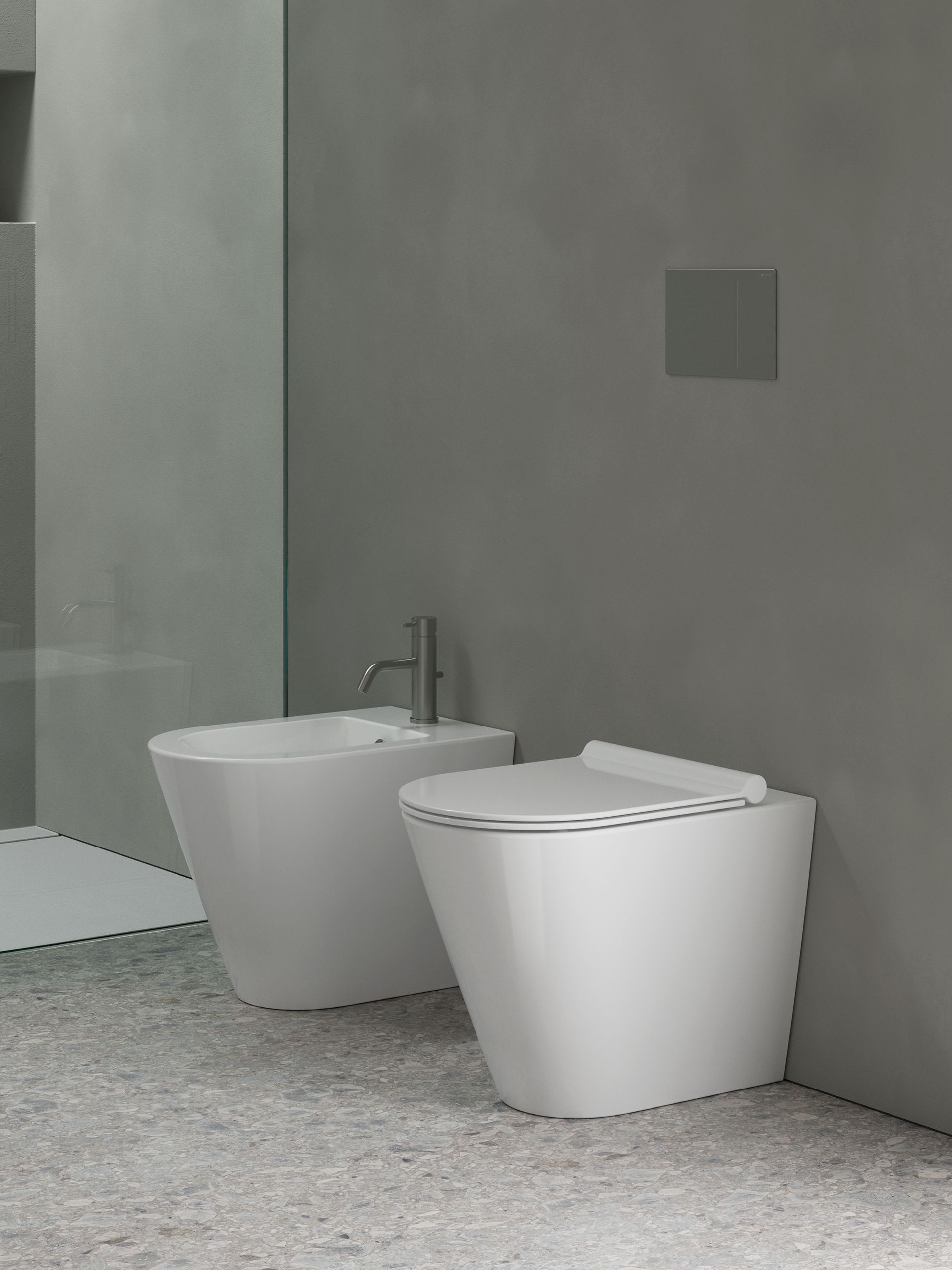Un bagno con due water bianchi e un lavandino