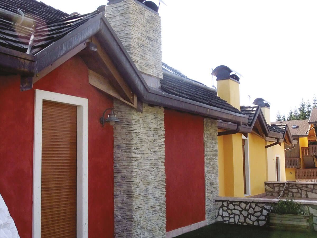 Un edificio rosso e giallo con un camino sul tetto