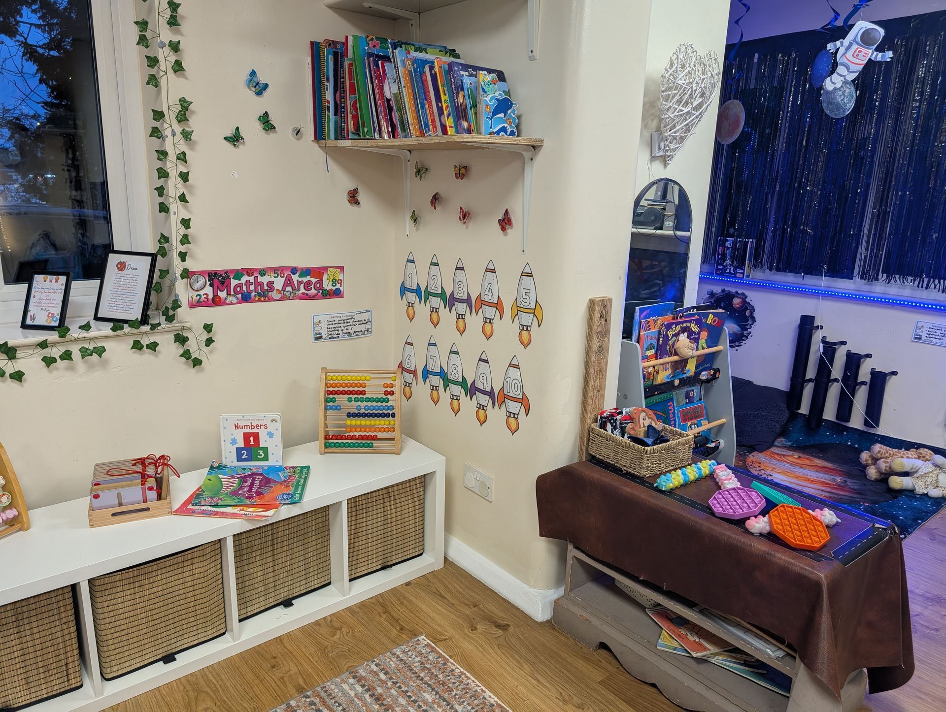 Colorful craft corner with shelves of supplies, wall art, and a window seat with pillows and a blanket