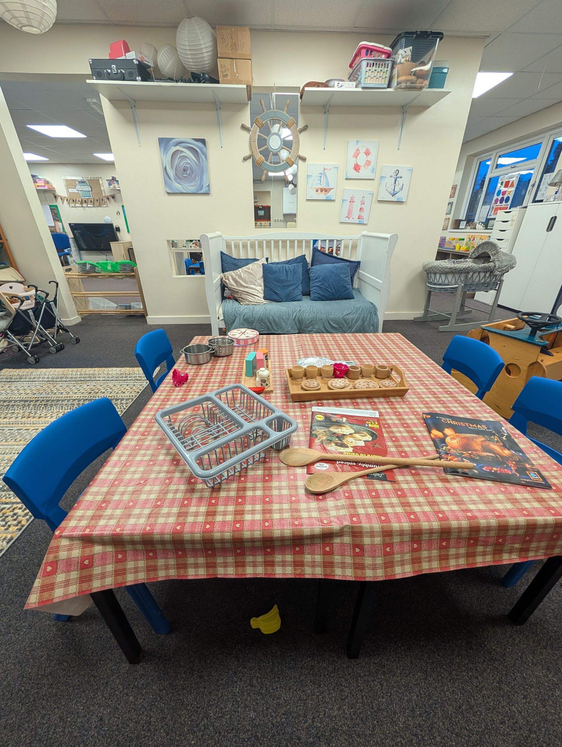 Table with checkerboard cloth and snacks in a shop seating area, with blue chairs and shelves in the background