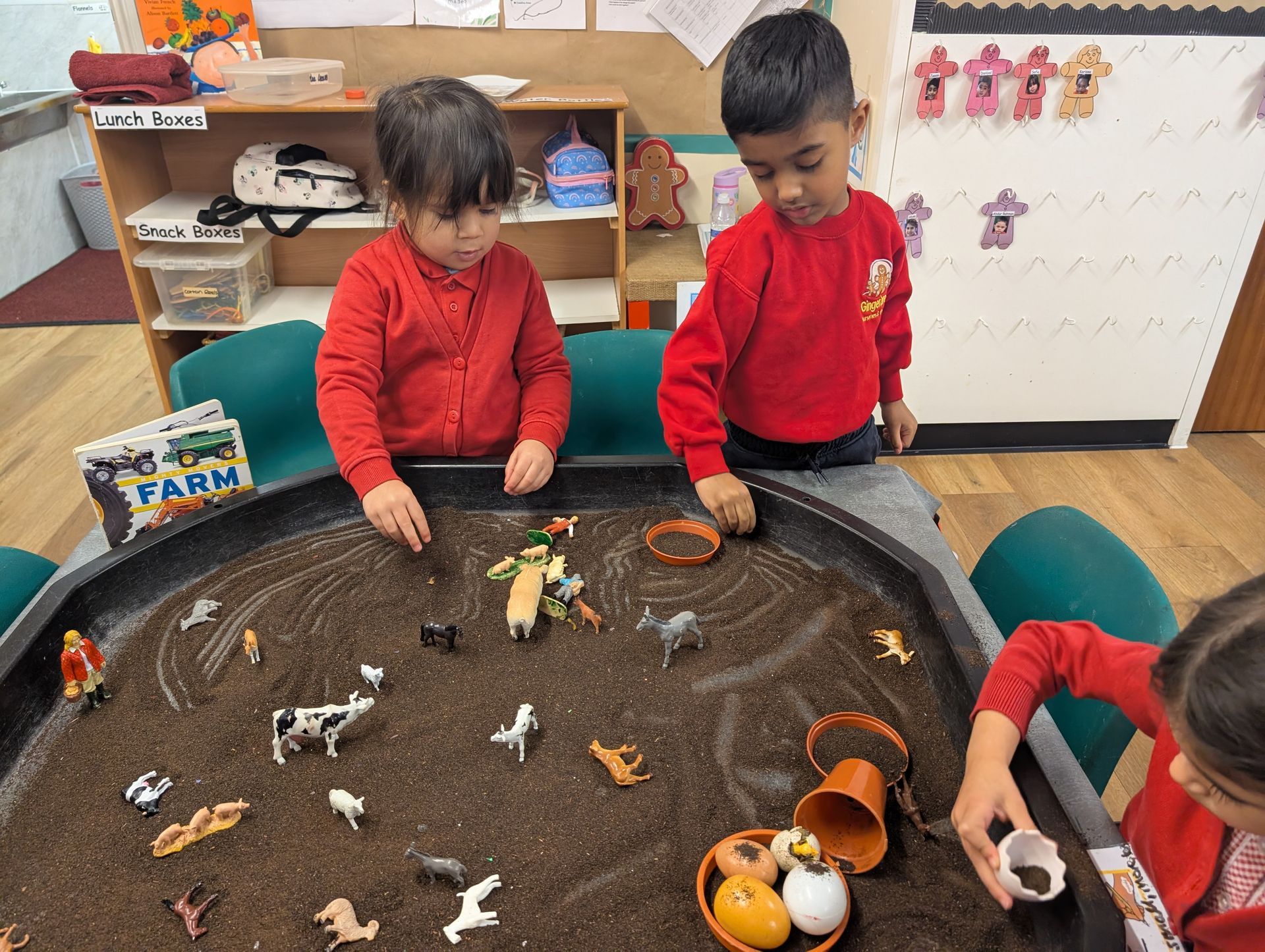 children playing with farm animal messy play tuff tray at gingerbread cottage playgroup
