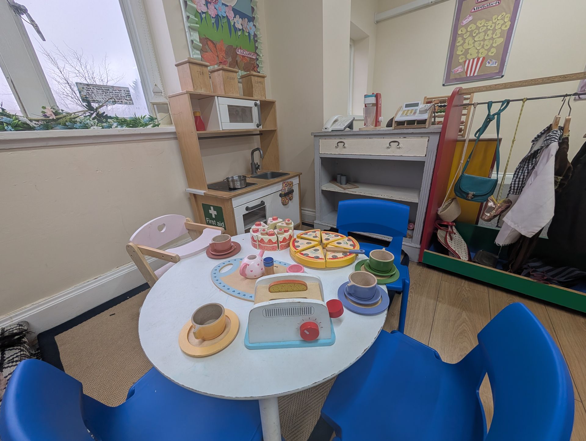 Children’s play table with toy food and dishes in a colorful playroom