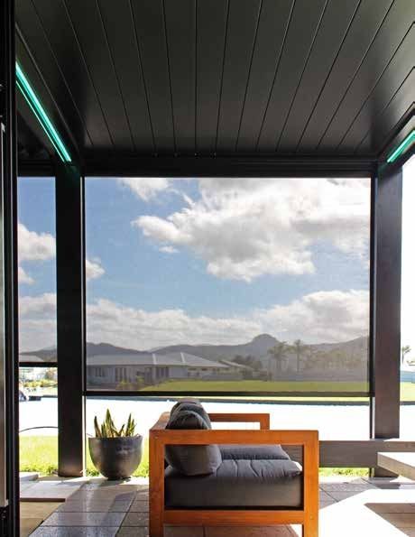 A living room with a couch and a chair and a large window.
