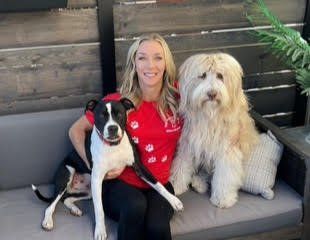 A woman is sitting on a couch with two dogs.