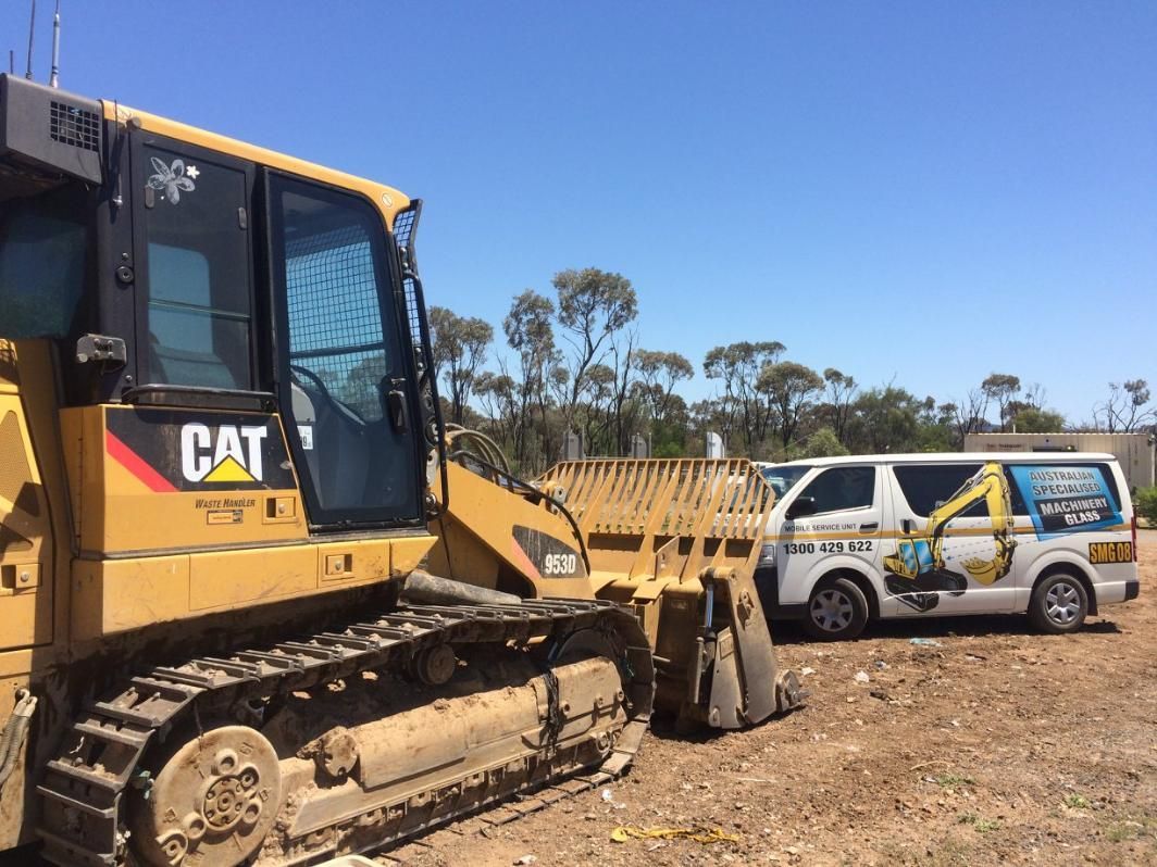 A Bulldozer Is Parked Next To A Van In A Field — Australian Specialised Machinery Glass In Mount Louisa, QLD