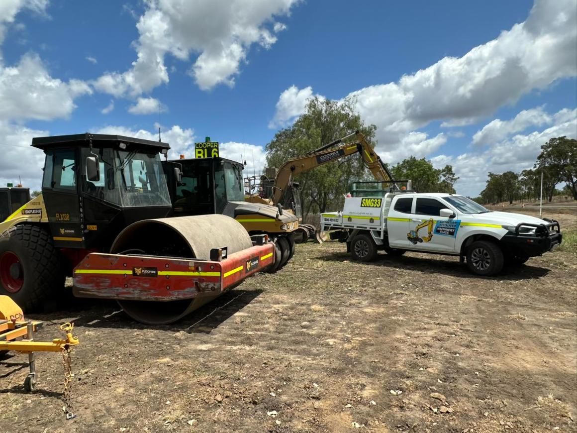 A Tractor And A Truck Are Parked Next To Each Other In A Dirt Field — Australian Specialised Machinery Glass In Mount Louisa, QLD