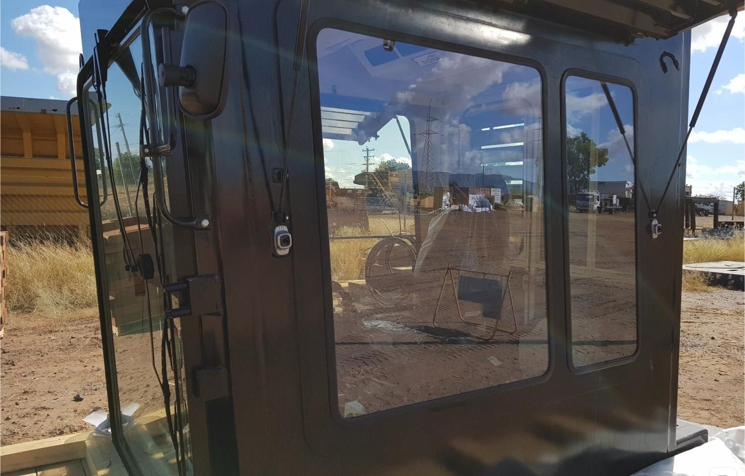 A black cab with clear windows is sitting in a construction zone — Australian Specialised Machinery Glass In Mount Louisa, QLD